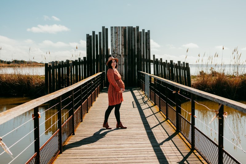 Un couple assiste à un enfant et partage un moment complice sous la lumière dorée d'Aigues-Mortes