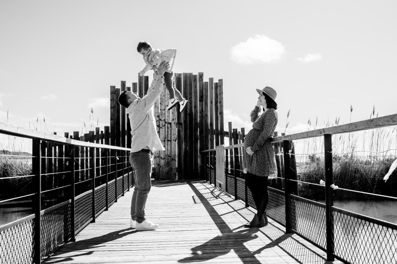 Un couple assiste à un enfant et partage un moment complice sous la lumière dorée d'Aigues-Mortes