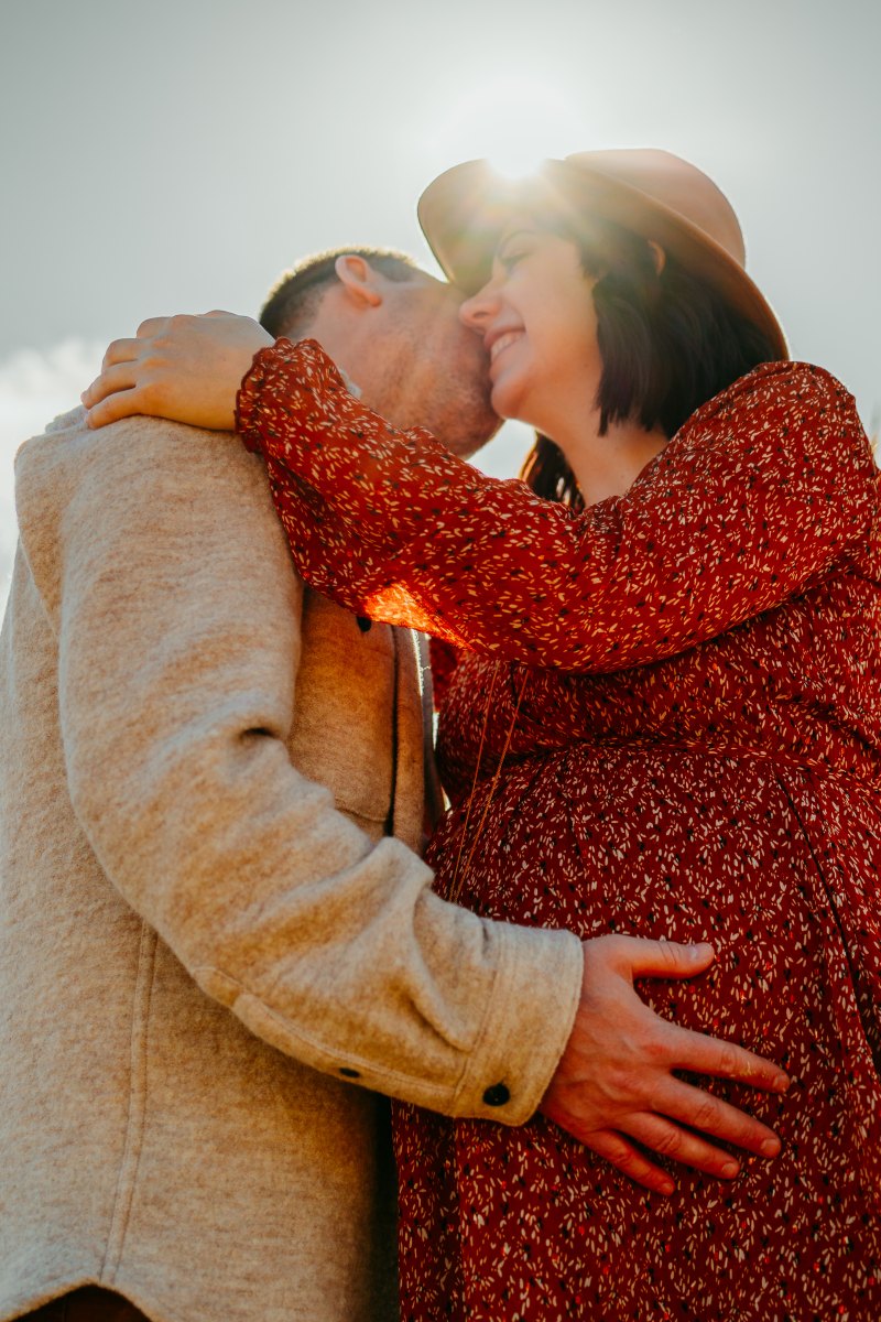 Un couple assiste à un enfant et partage un moment complice sous la lumière dorée d'Aigues-Mortes