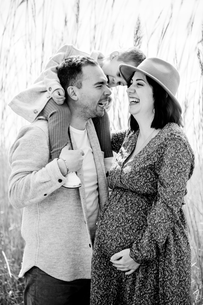 Un couple assiste à un enfant et partage un moment complice sous la lumière dorée d'Aigues-Mortes